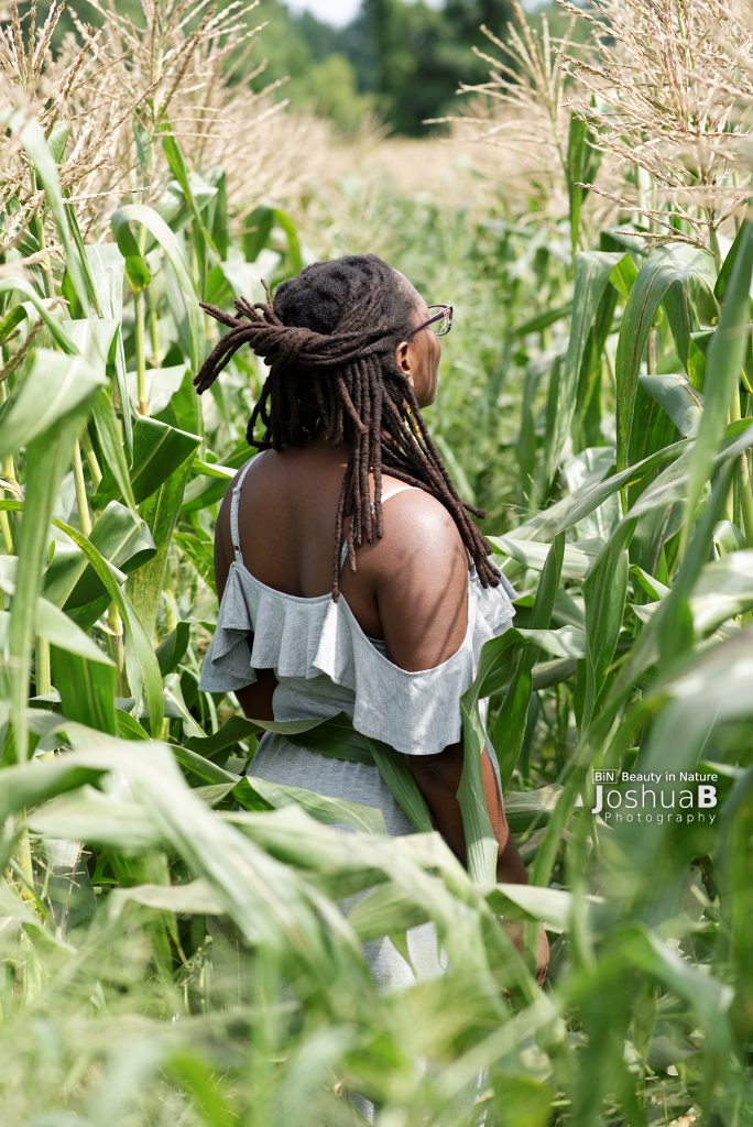 Woman with dreadlocks in cornfield