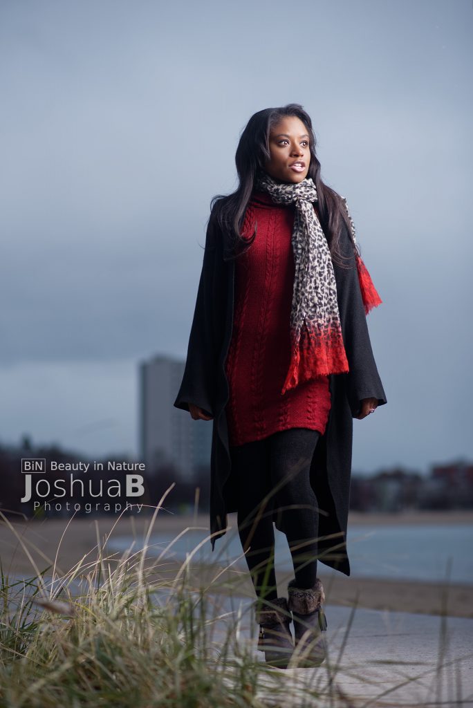 Beautiful young black woman modeling in sweater and scarf at Carson Beach