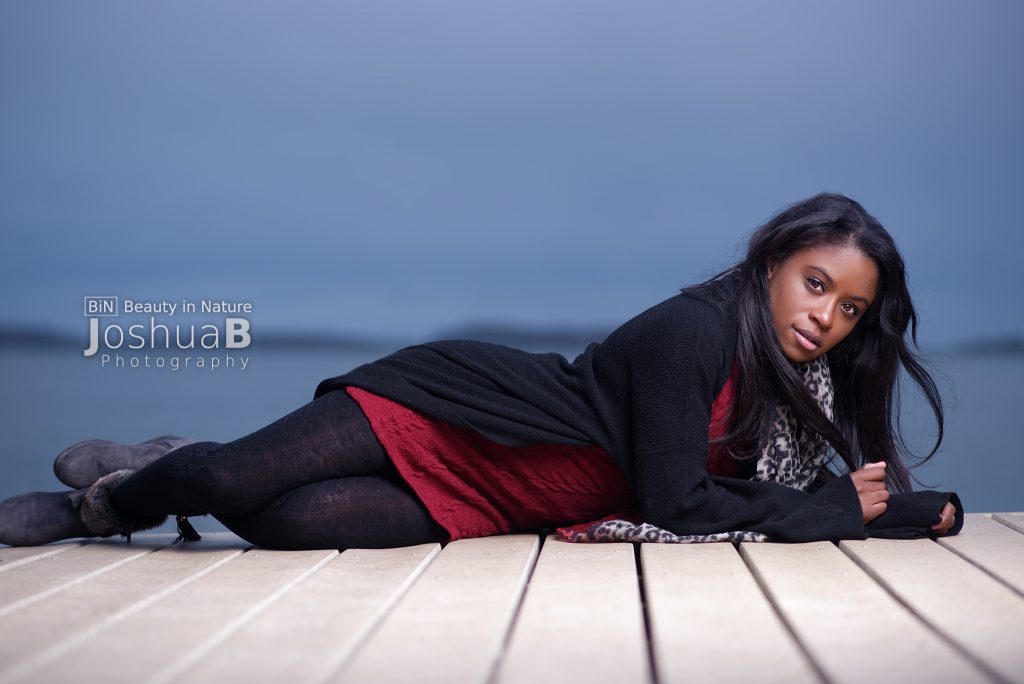 Beautiful young black woman modeling on boardwalk at Carson Beach in Boston