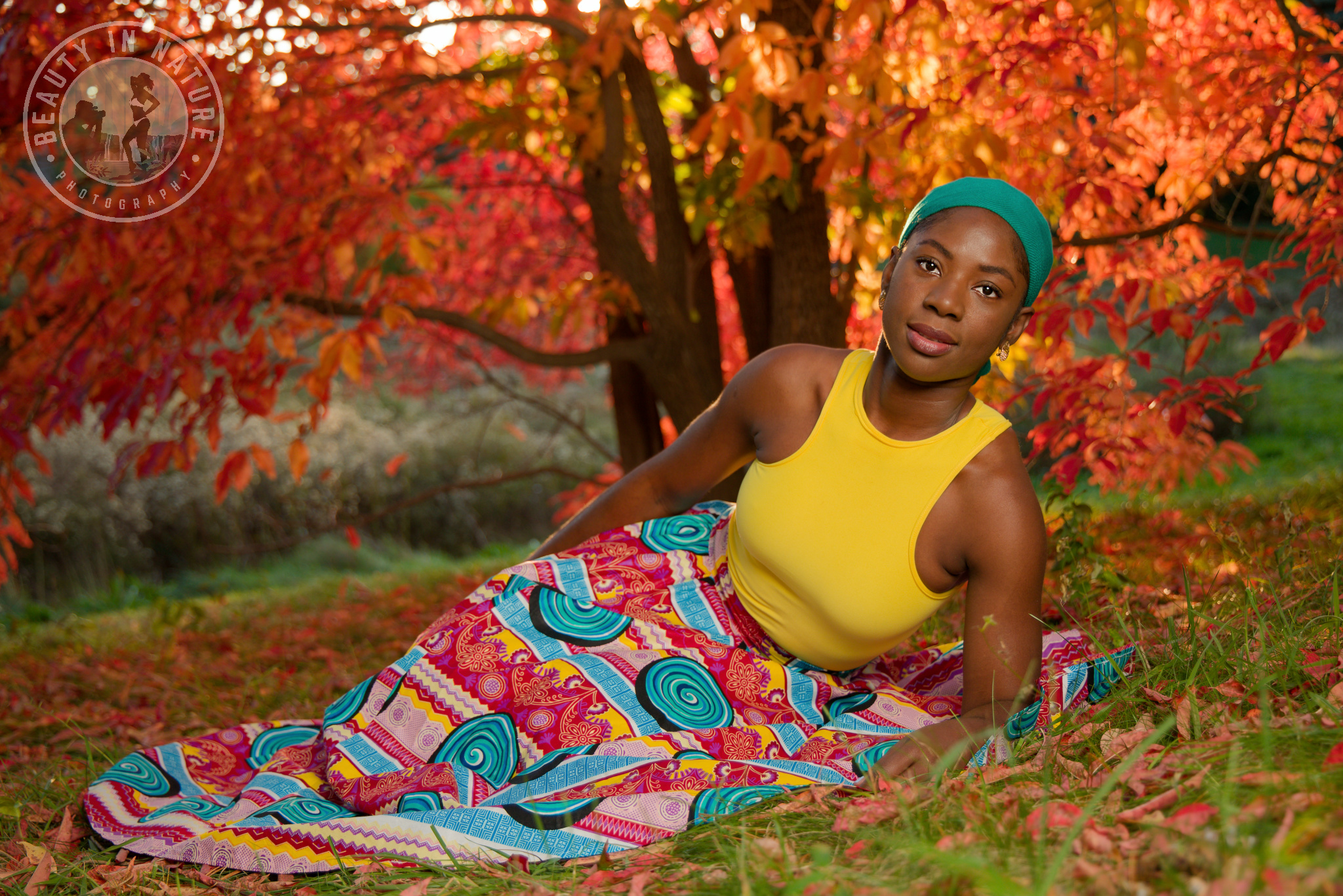 Beautiful young Haitian woman in African skirt and yellow tank top fall foliage