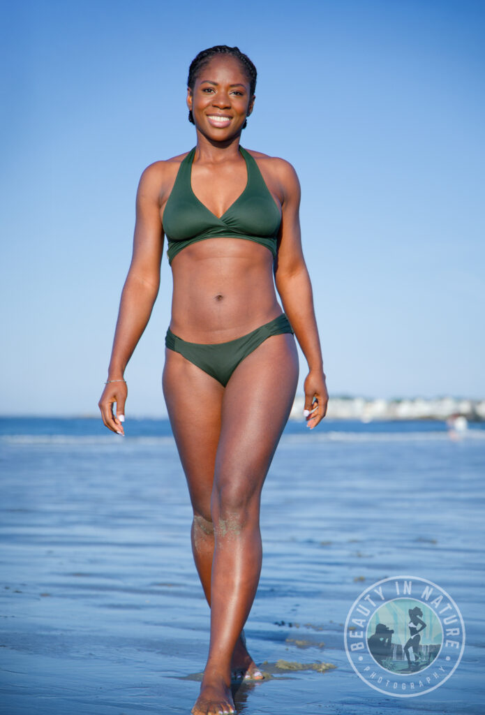 Beautiful Haitian American woman in green bikini walking along Nantasket Beach